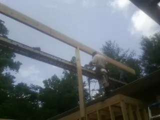 Carpenter setting a ridge beam over a new addition frame — Ice Dam Removal by Roofing Brothers in Ravenswood