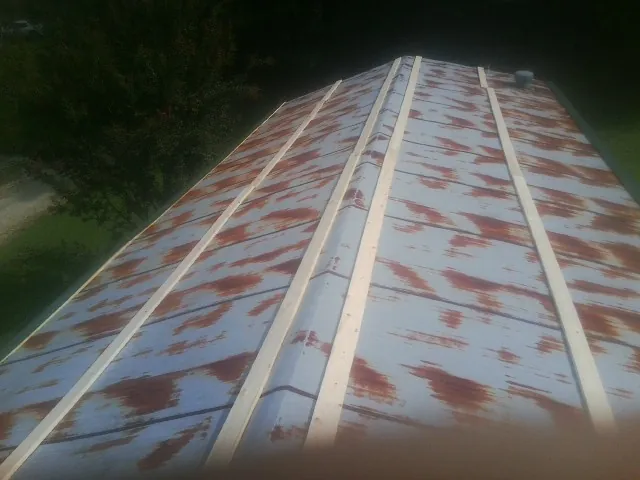 Rusted metal roof panels with new wood purlins before replacement — Storm Damage Roof Repair in Ravenswood by Roofing Brothers