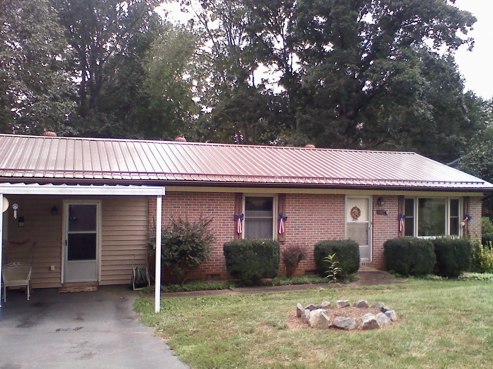 Bronze metal roof and carport on a brick ranch home — Roof Repair work by our crew in Ravenswood